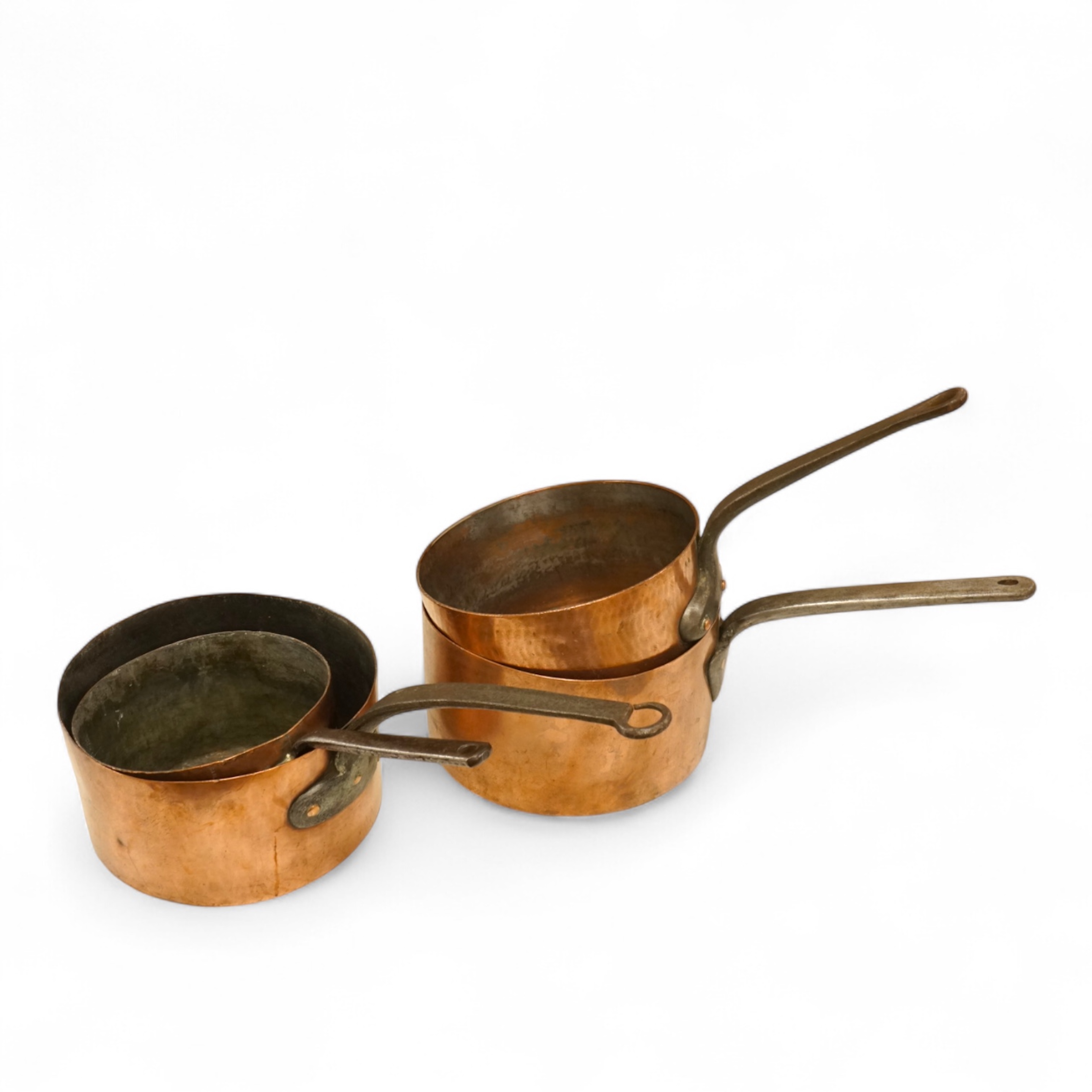 A graduated group of four large copper saucepans